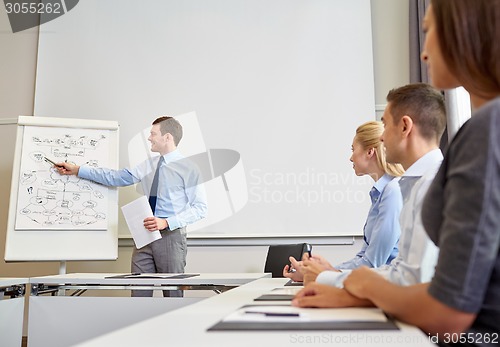 Image of group of smiling businesspeople meeting in office