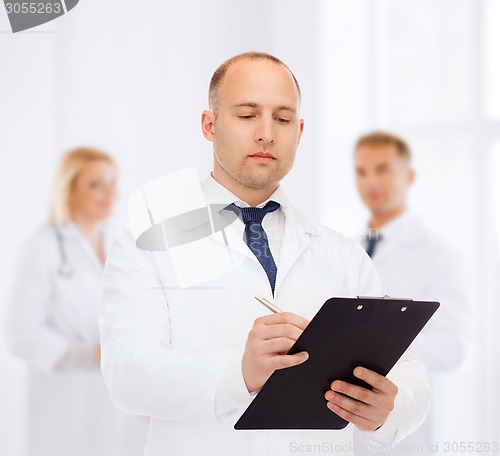 Image of serious male doctor with clipboard