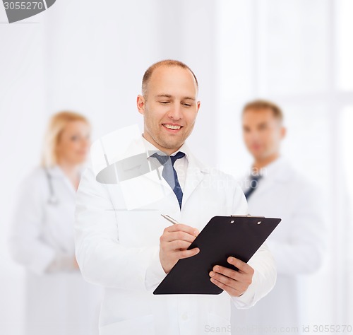 Image of smiling male doctor with clipboard