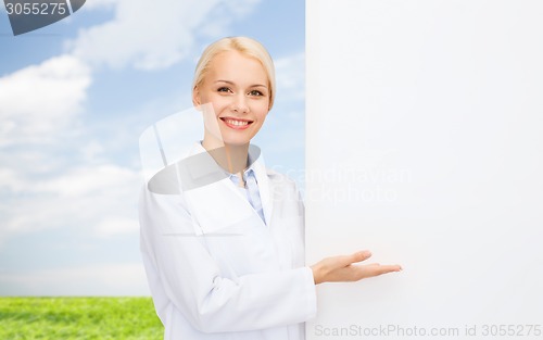 Image of smiling female doctor with white blank board