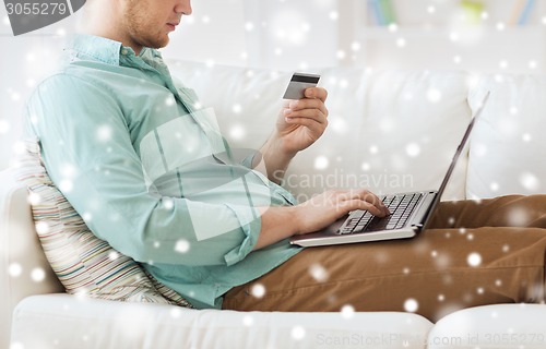 Image of close up of man with laptop and credit card