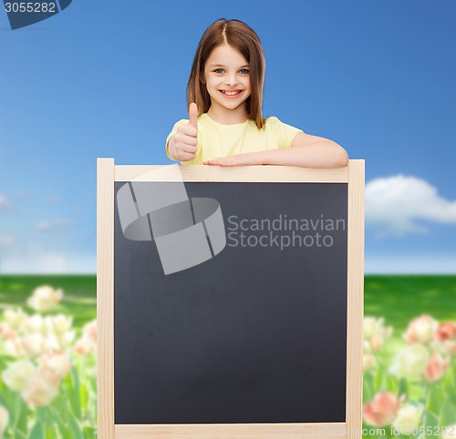 Image of happy little girl with blank blackboard