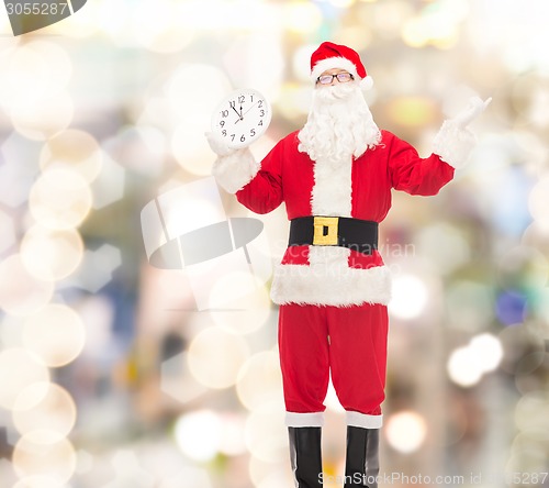 Image of man in costume of santa claus with clock