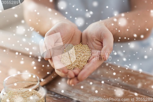 Image of close up of male cupped hands with quinoa