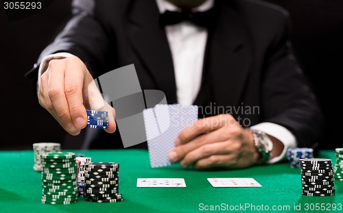 Image of poker player with cards and chips at casino