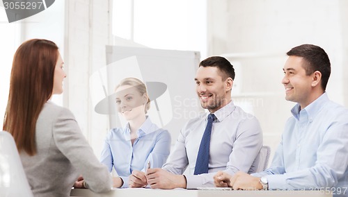 Image of smiling businesswoman at interview in office