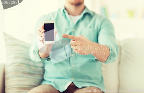 Image of close up of man sitting with smartphone at home