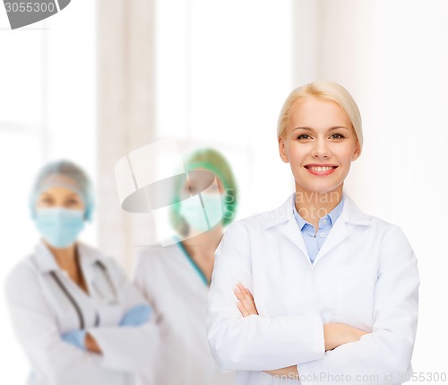 Image of smiling female doctor with group of medics