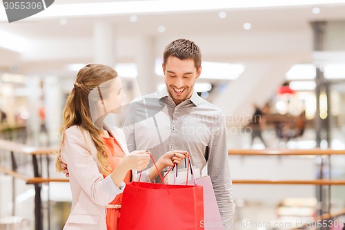 Image of happy young couple with shopping bags in mall