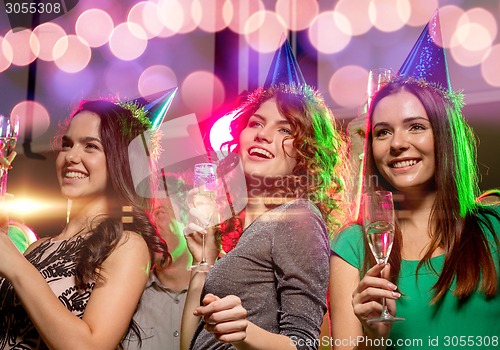 Image of smiling friends with glasses of champagne in club