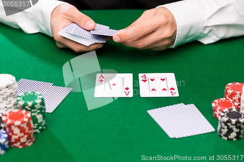 Image of holdem dealer with playing cards and casino chips