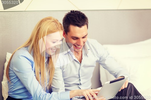 Image of couple with tablet pc computer in hotel room