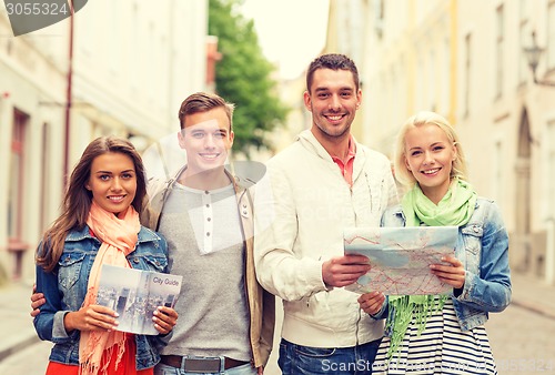 Image of group of smiling friends with city guide and map