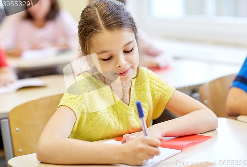 Image of group of school kids writing test in classroom