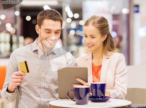 Image of couple with tablet pc and credit card in mall