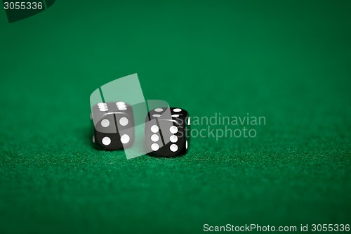 Image of close up of black dice on green casino table