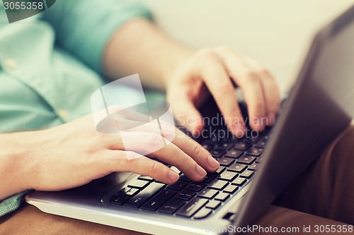 Image of close up of man working with laptop at home