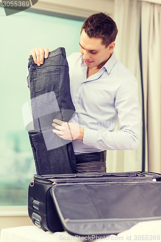 Image of businessman packing things in suitcase