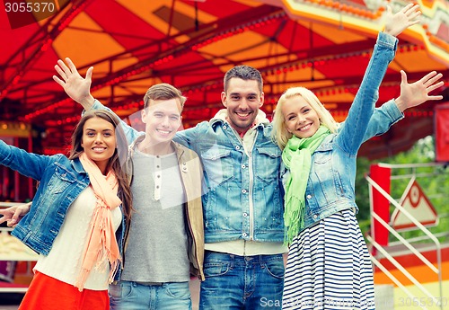 Image of group of smiling friends waving hands