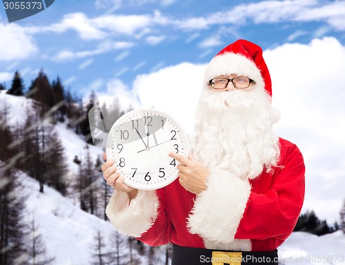Image of man in costume of santa claus with clock