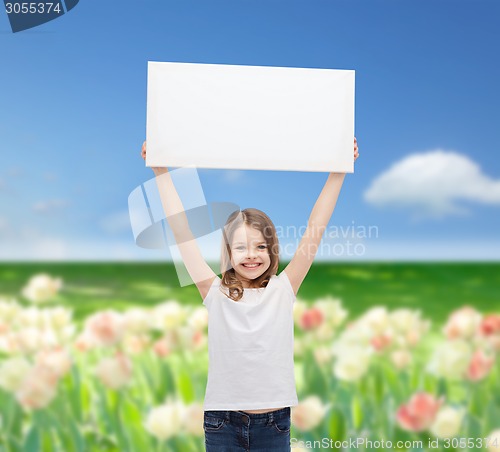 Image of smiling little girl holding blank white board