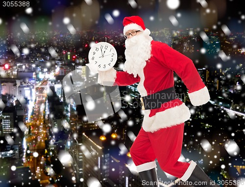 Image of man in costume of santa claus with clock