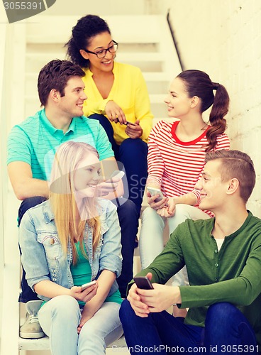Image of smiling students with smartphone having discussion