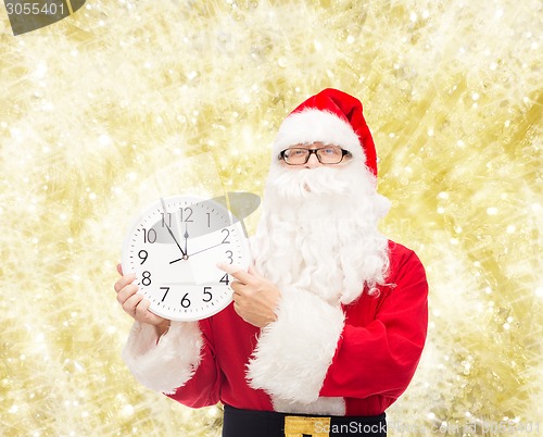 Image of man in costume of santa claus with clock