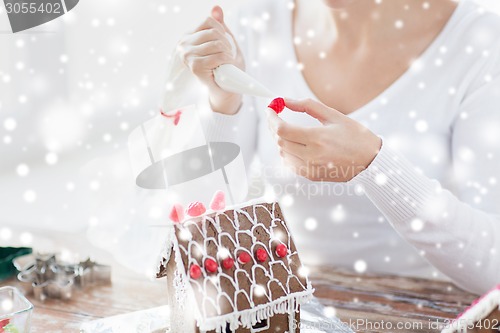 Image of close up of woman making gingerbread houses