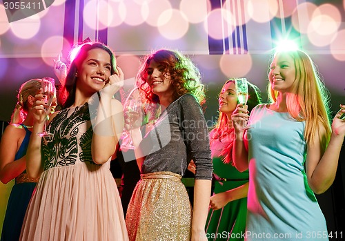 Image of smiling friends with glasses of champagne in club