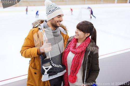 Image of happy couple with ice-skates on skating rink