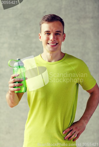 Image of smiling man with bottle of water in gym