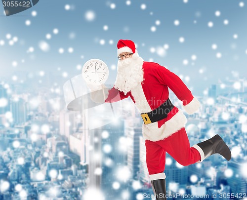 Image of man in costume of santa claus with clock