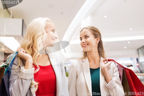 Image of happy young women with shopping bags in mall