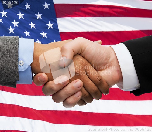 Image of close up of handshake over american flag