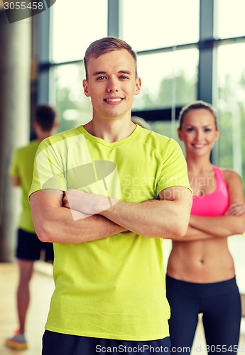 Image of smiling man and woman in gym