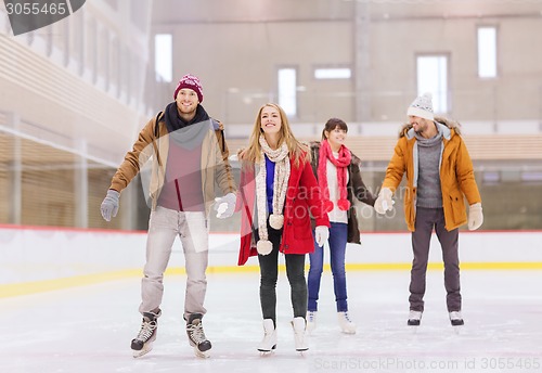 Image of happy friends on skating rink