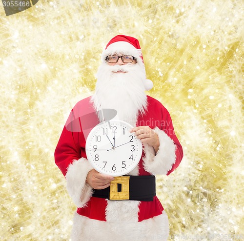 Image of man in costume of santa claus with clock