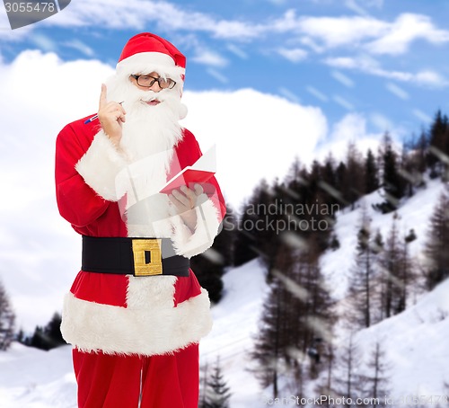 Image of man in costume of santa claus with notepad
