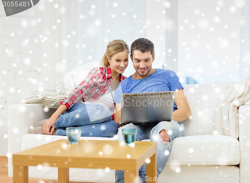 Image of smiling couple with laptop computer at home
