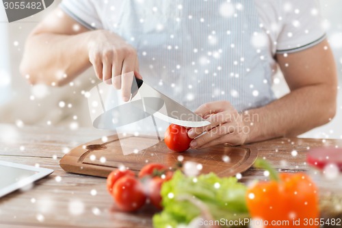 Image of close up of man cutting vegetables with knife