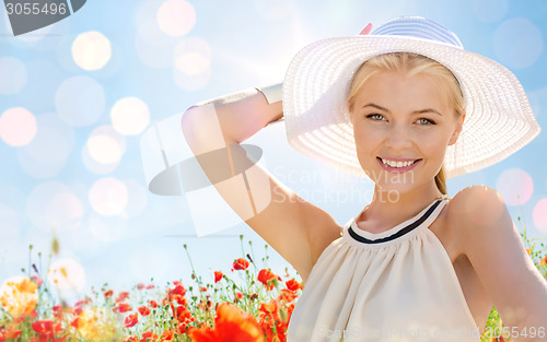 Image of smiling young woman in straw hat on poppy field