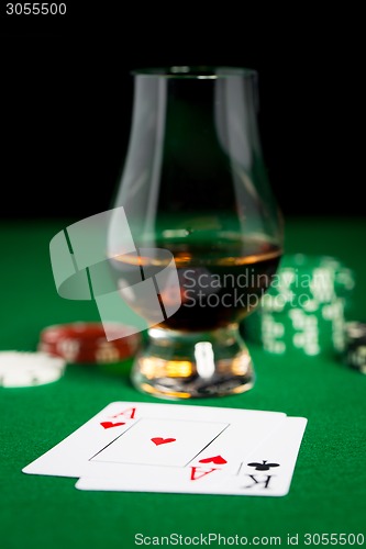 Image of close up of chips, cards and whisky glass on table