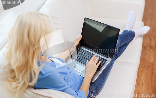 Image of smiling woman with laptop computer at home