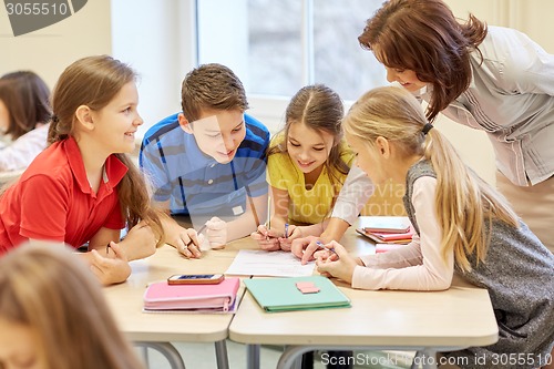 Image of group of school kids writing test in classroom