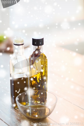 Image of close up of two olive oil bottles and glass bowl