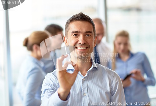 Image of group of smiling businesspeople meeting in office