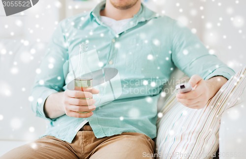 Image of man with beer and remote control at home
