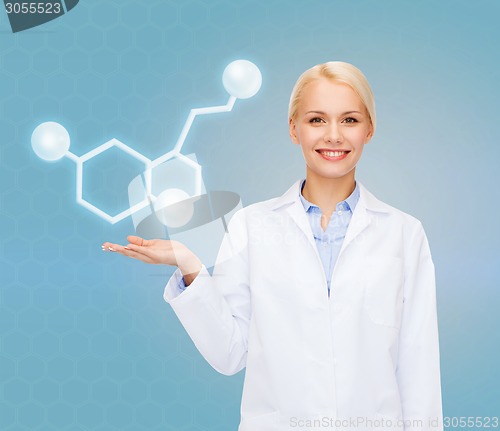 Image of smiling female doctor pointing to molecule