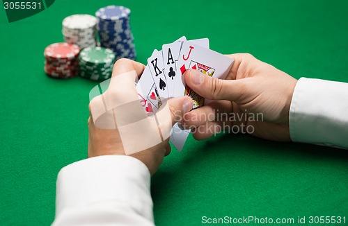 Image of poker player with cards and chips at casino